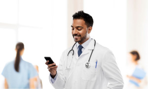 smiling indian male doctor with smartphone